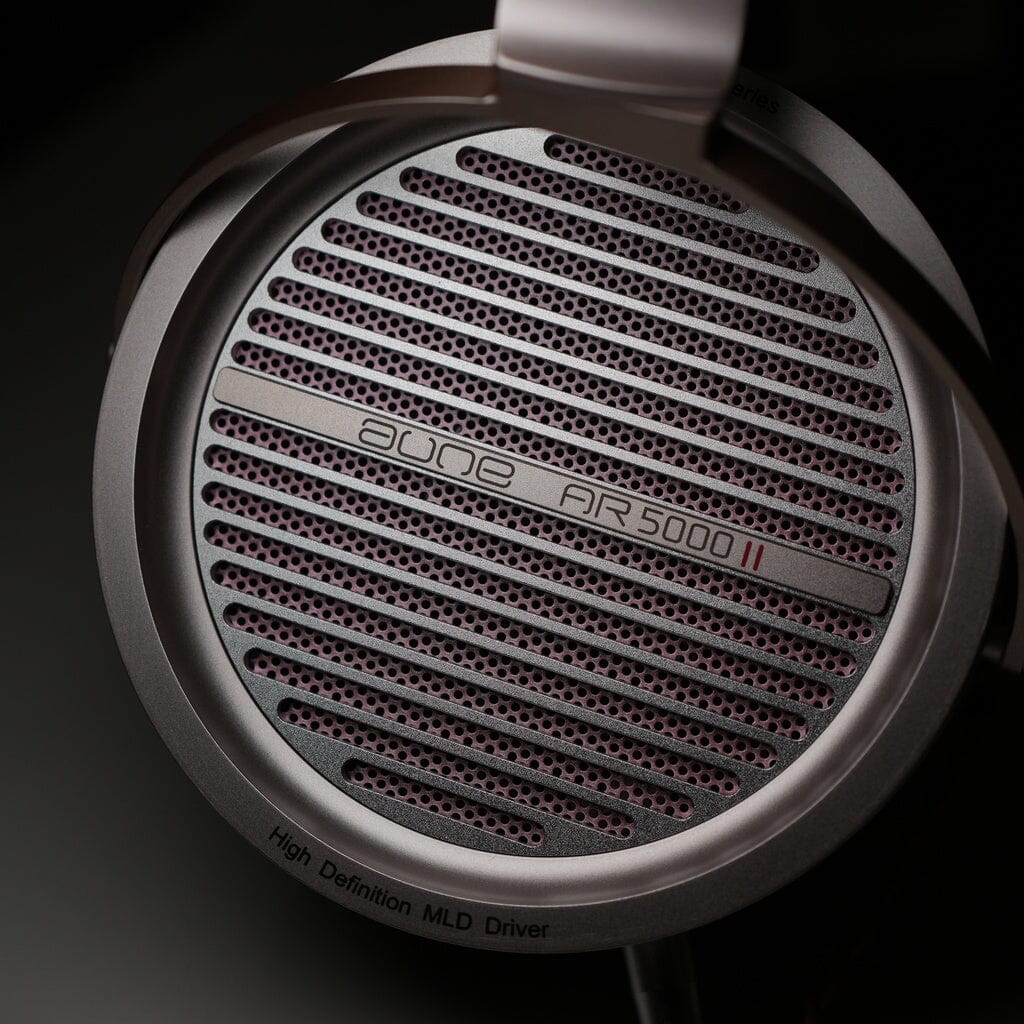 Close-up of a silver headphone earcup, featuring the grille labeled Aune Audio AR5000 MK2 with a fine mesh pattern and the text High Definition MLD Driver on the rim. These open-back dynamic headphones are equipped with an advanced 50mm driver for truly immersive sound quality.