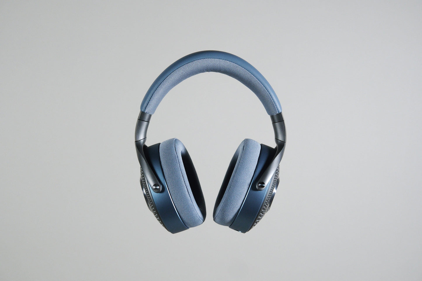A pair of Focal Azurys closed-back, over-ear headphones by Focal in blue and gray is shown against a plain light gray background.