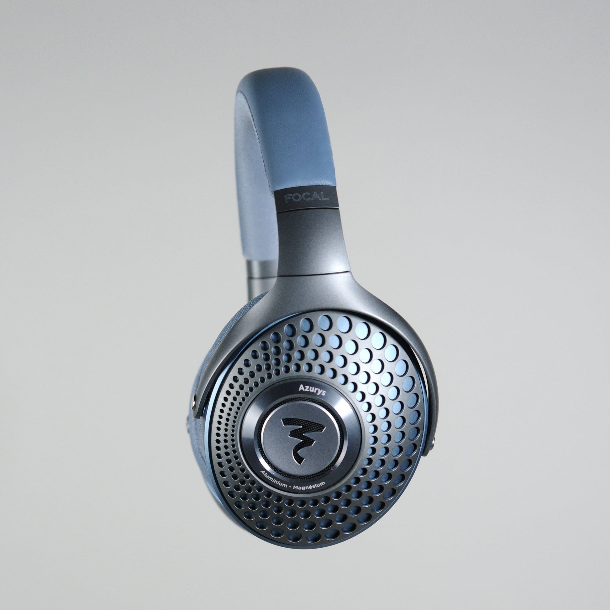 A pair of Focal Azurys closed-back headphones by Focal, featuring a circular perforated earcup design and visible branding on the headband, photographed against a light grey background.