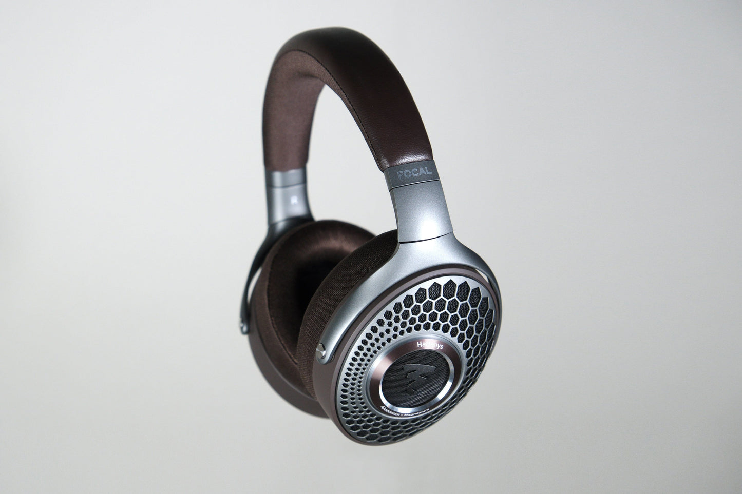 The Focal Hadenys by Focal are over-ear headphones with a brown headband, silver accents, and honeycomb design, featuring aluminium/magnesium drivers, pictured against a plain light background.