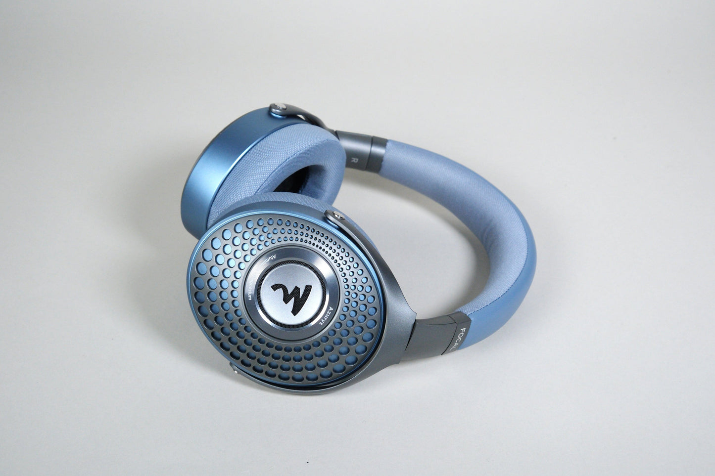 Focal Azurys blue over-ear headphones by Focal feature a textured circular ear cup design with a central W logo, shown against a plain light gray background.