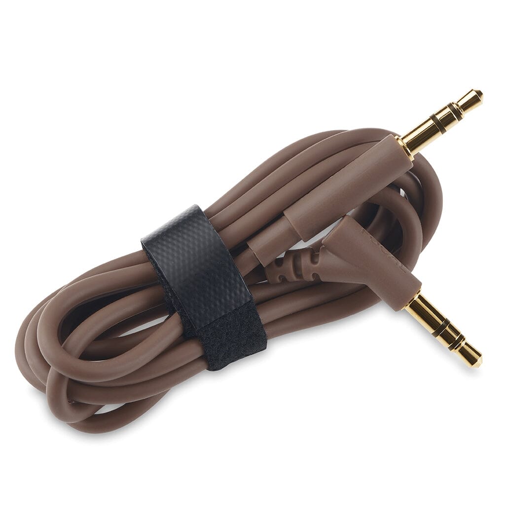 A brown coiled audio cable with gold-plated 3.5mm connectors (one straight, one right-angled), designed for Focal Bathys MG Wireless Headphones by Focal, secured with a black Velcro strap.