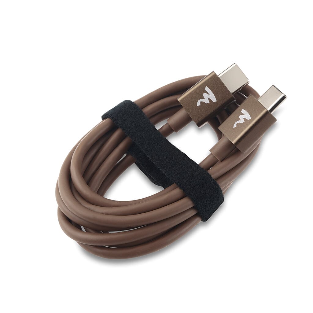 A coiled brown USB-C to USB-C cable with two connectors, each marked with a white Focal logo, is secured by a black hook-and-loop strap and designed for the Focal Bathys MG Wireless Headphones by Focal.