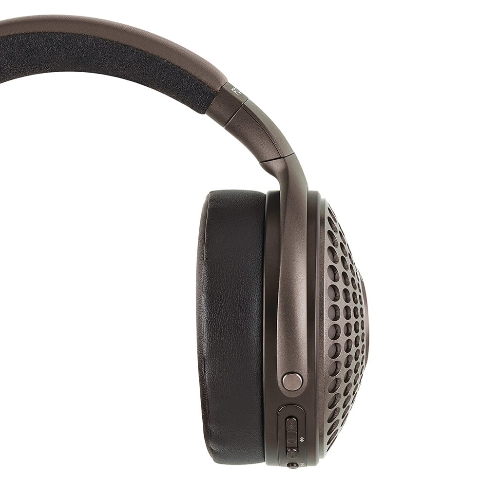 A close-up side view of a single Focal Bathys MG Wireless Headphone by Focal, featuring a perforated outer ear cup and cushioned headband, set against a white background.