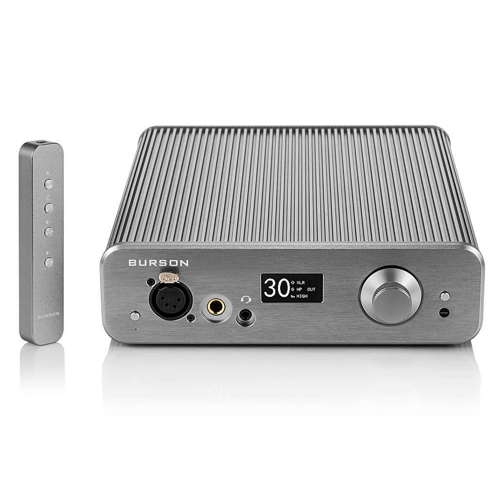 The Burson Audio Soloist 3X Performance is a silver amplifier with a matching remote, featuring a volume knob, digital display, and audio ports on its sleek ridged metal front. Inside, advanced Max Current Power Supplies ensure top performance.