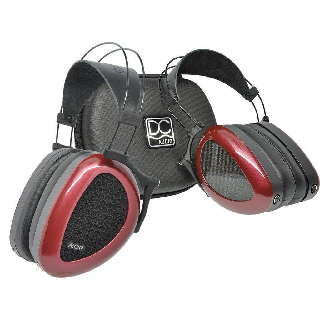 A pair of Dan Clark Audio AEON 2 Closed Headphones with red earcups and a black headband is shown in front of a matching black carrying case featuring the Dan Clark Audio logo.
