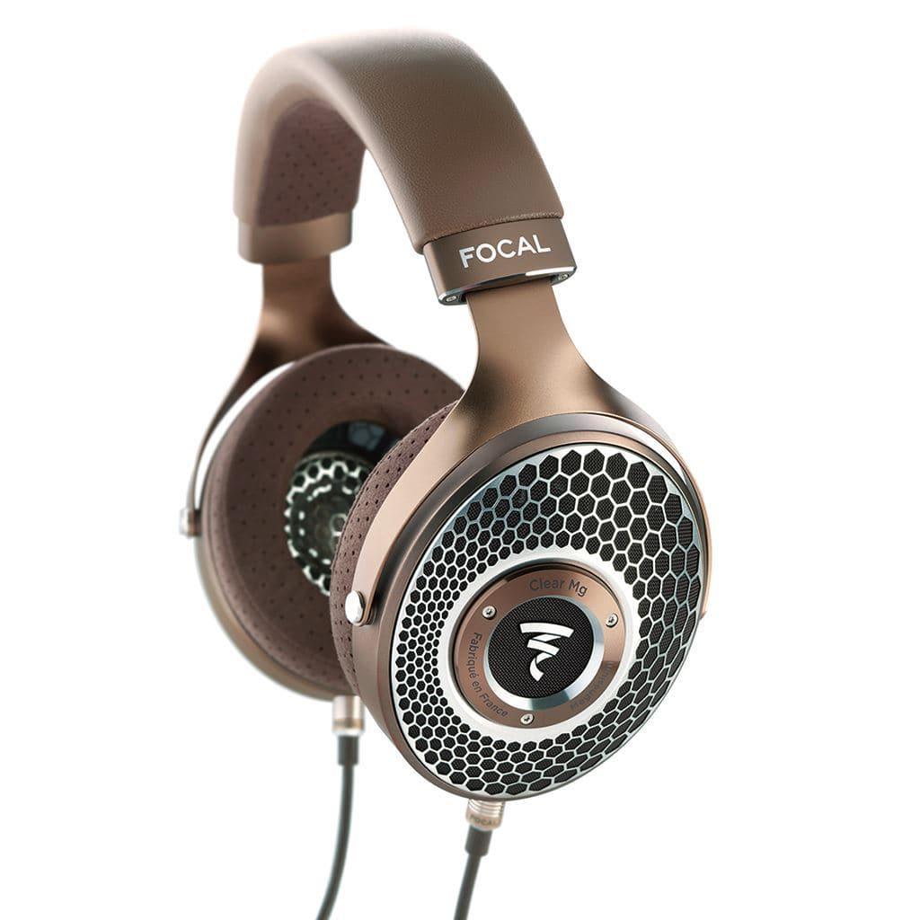 A pair of Focal Clear Mg over-ear open-back headphones by Focal, featuring a brown and metallic finish, honeycomb grille design, branded ear cups, and cable connection.