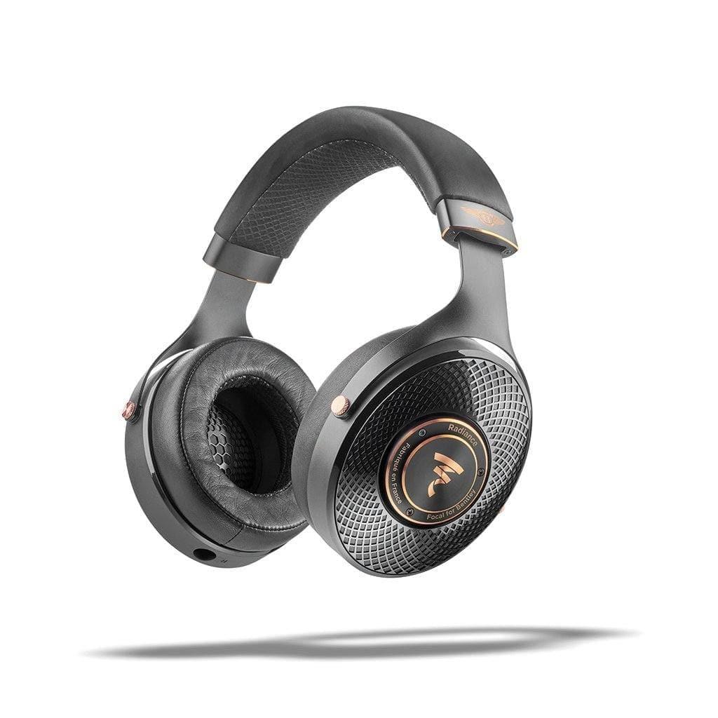 The Focal Radiance - Open Box by Focal features black over-ear cups with gold accents and a textured mesh design, inspired by Bentley design elements, shown floating above a shadow on a white background.