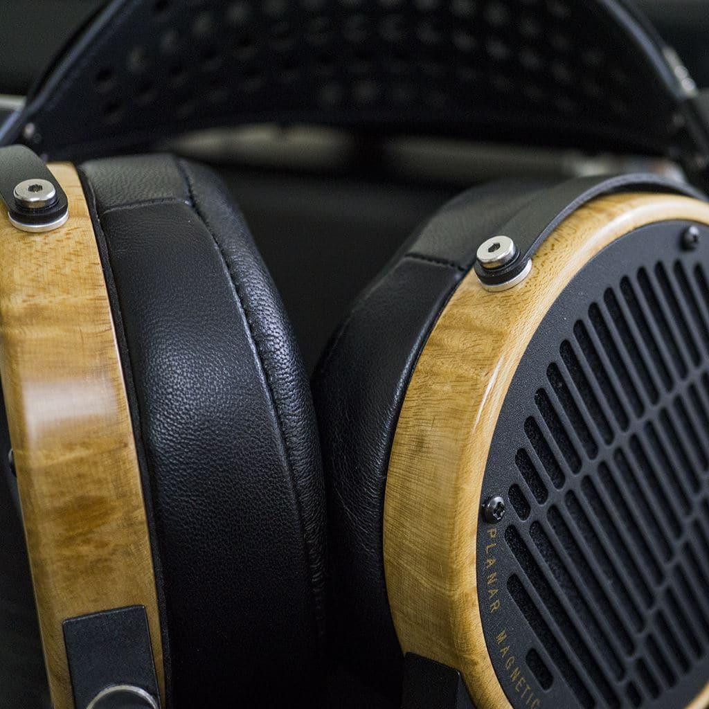 Close-up of Audeze LCD-3 headphones by Audeze, featuring wooden ear cups, black leather ear pads, and metal accents. The words “Planar Magnetic” are partially visible, highlighting their Hi-Fi listening appeal.