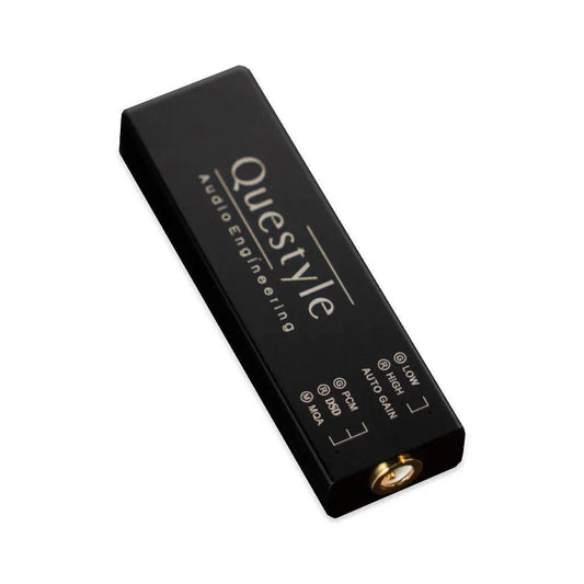 The Questyle M12i Portable USB DAC & Headphone Amp is a compact black rectangular device with gold input jack and labeled switches for LOW, HIGH, AUTO GAIN, DSD, PCM, and MOA—ideal for lossless mobile Hi-Fi music.