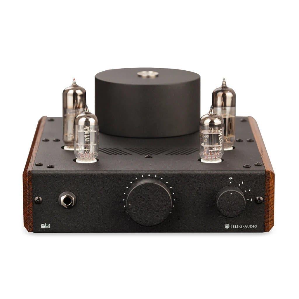 The Feliks Audio Echo MK II by Feliks Audio is a black tube amplifier with wooden side panels, four vacuum tubes on top, and a central control knob on the front, highlighting its OTL design. It is shown against a white background.