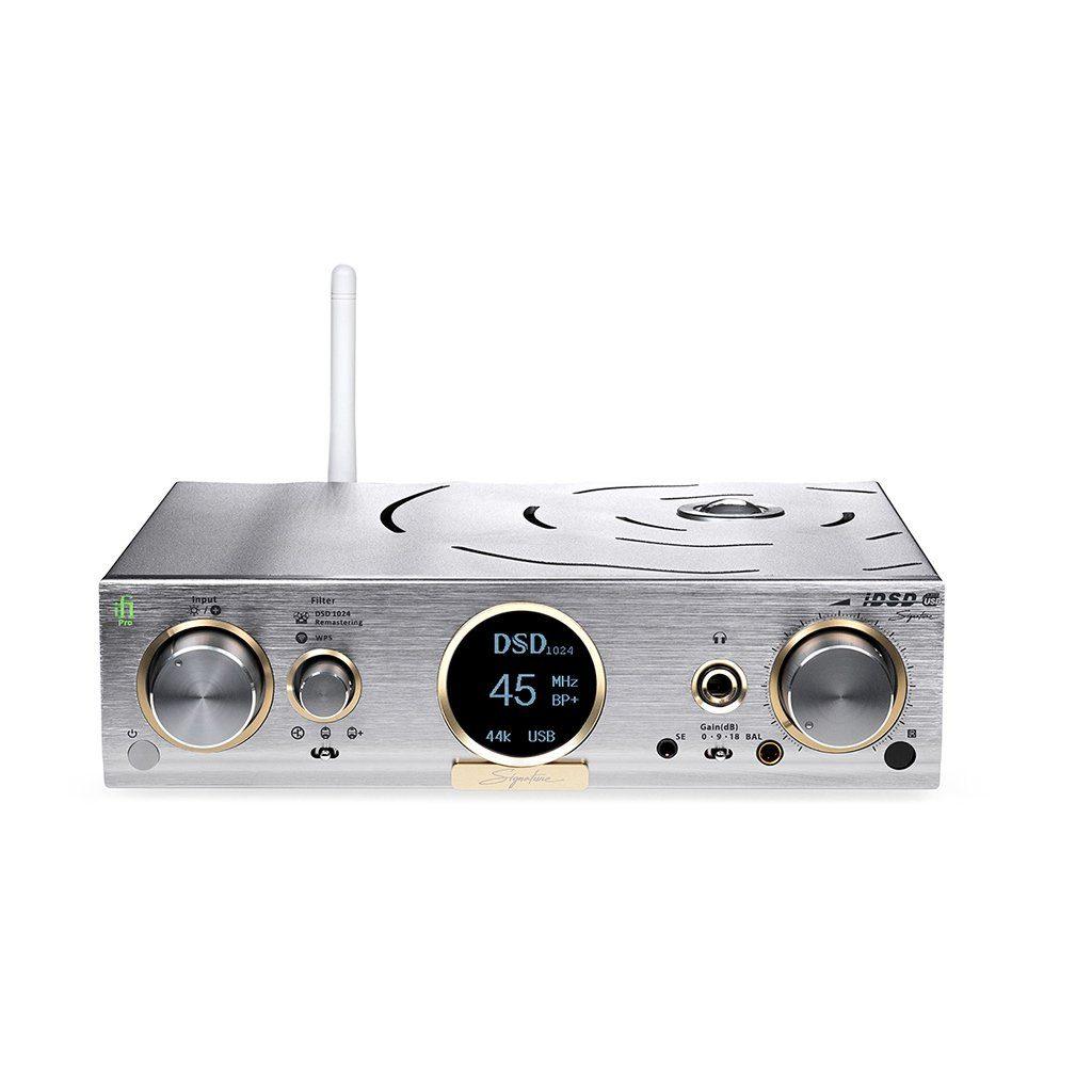 The iFi Audio Pro iDSD Signature DAC/Amp & Streamer by iFi Audio features silver and gold accents, multiple control knobs, input/output ports, a white network streamer antenna, and a digital display showing DSD 45 44k USB on the front panel.