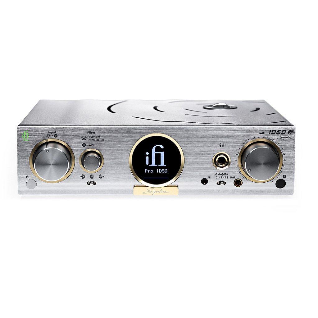 The iFi Audio Pro iDSD Signature DAC/Amp & Streamer by iFi Audio features a silver finish with gold accents, control knobs, multiple input/output jacks, a digital display, and engraved details on its front panel.