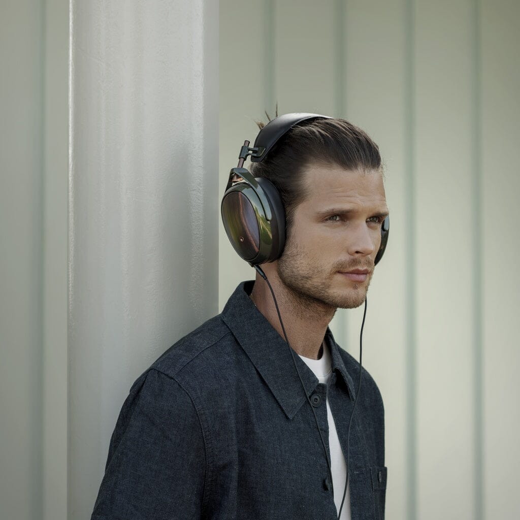 A man wearing Meze Audio Strada closed-back dynamic headphones, enjoying perfect tonal balance.