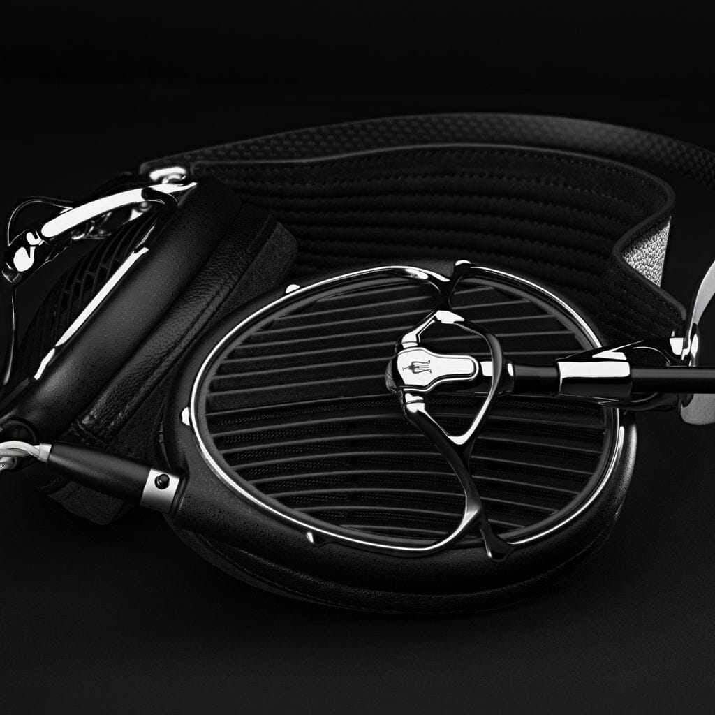 Close-up of the Meze Audio ARTA Headphones by Meze, featuring a high-end black and silver open-back design with a distinctive grille, plush cushioned ear pads, and a textured headband, all showcased against a dark background.
