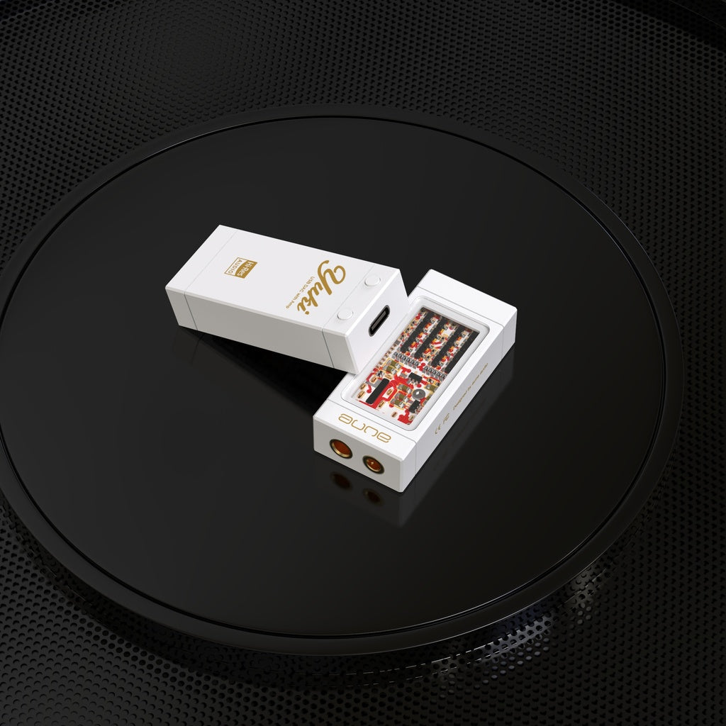 Two white electronic devices, including one with exposed circuitry, rest on a glossy black circular surface with a textured background, highlighting the sleek design of the Aune Audio YUKI Portable DAC and Headphone Amplifier from Aune Audio.