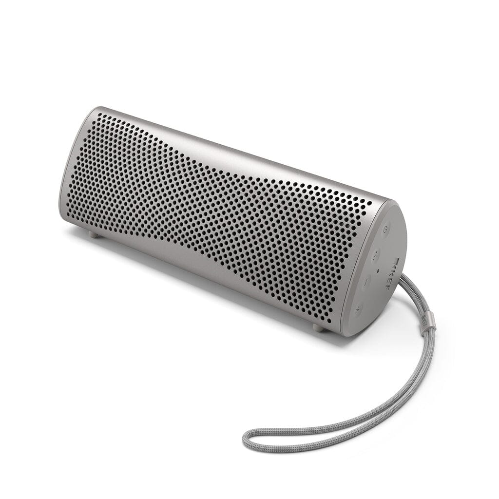 The KEF Muo HiFi Portable Bluetooth Speaker by KEF features a sleek cylindrical design, perforated metal grille, rounded edges, and built-in carrying strap, displayed against a white background.
