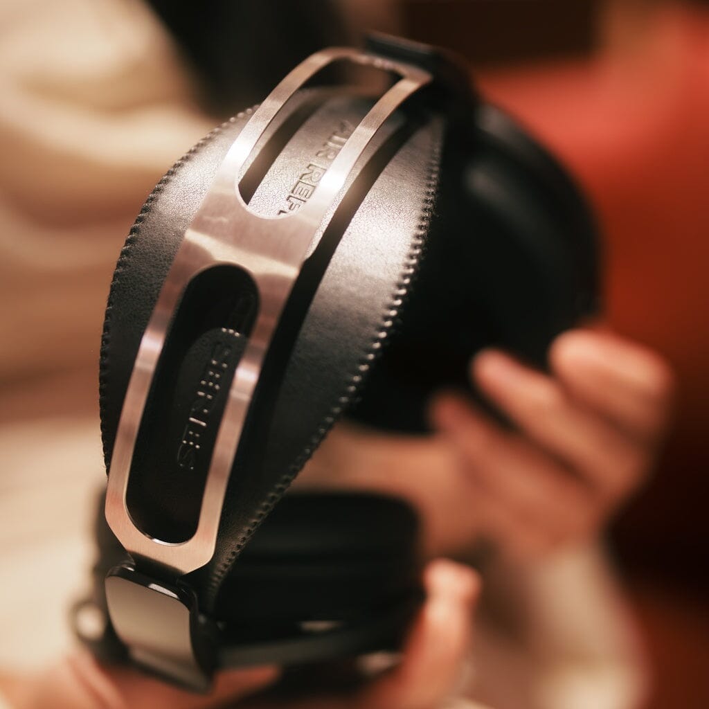 Aune Audio AR3000 over-ear headphones with a prominent metal headband frame featuring cutout detailing and visible text, available in the US.