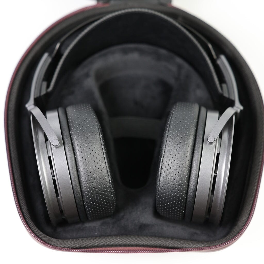 A pair of Aune AR9000 headphones by Aune Audio, featuring black perforated ear cushions, rests inside a black, form-fitting protective case.