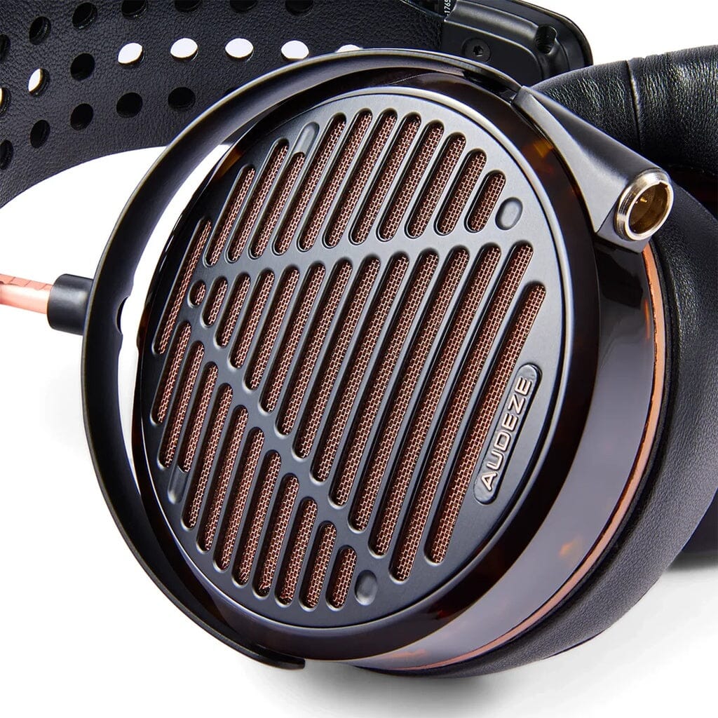 Close-up of the Audeze LCD-5s headphones ear cup, with a black and copper metal grill, Audeze logo, audio jack socket, and engineered for mastering-grade precision.