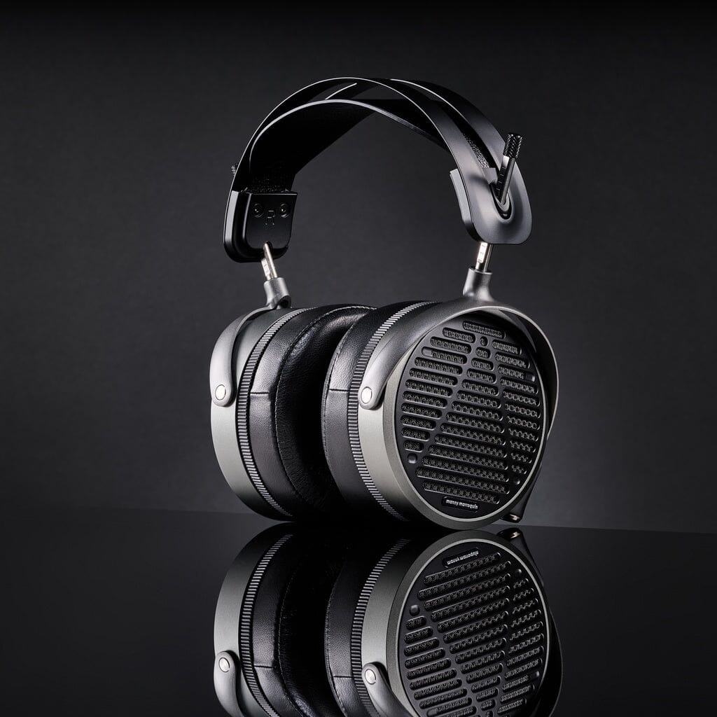 Audeze MM-520 Headphones by Audeze feature a modern, over-ear black design with a metallic frame and mesh earcups, planar magnetic drivers, and are shown on a glossy black surface with their reflection visible.