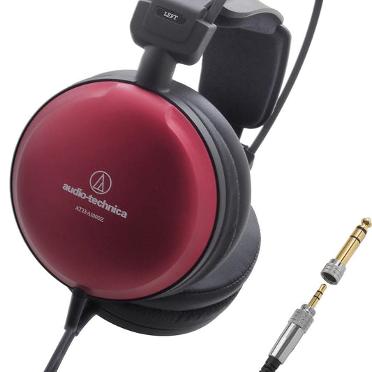 Close-up of red Audio-Technica ATH-A1000z Headphones - Open-Box - Clearance with a visible LEFT label on the headband. Two gold-plated audio adapters, one attached to the cable, are displayed in the lower right corner, highlighting the premium build and signature 53mm dynamic drivers from Audio-Technica.