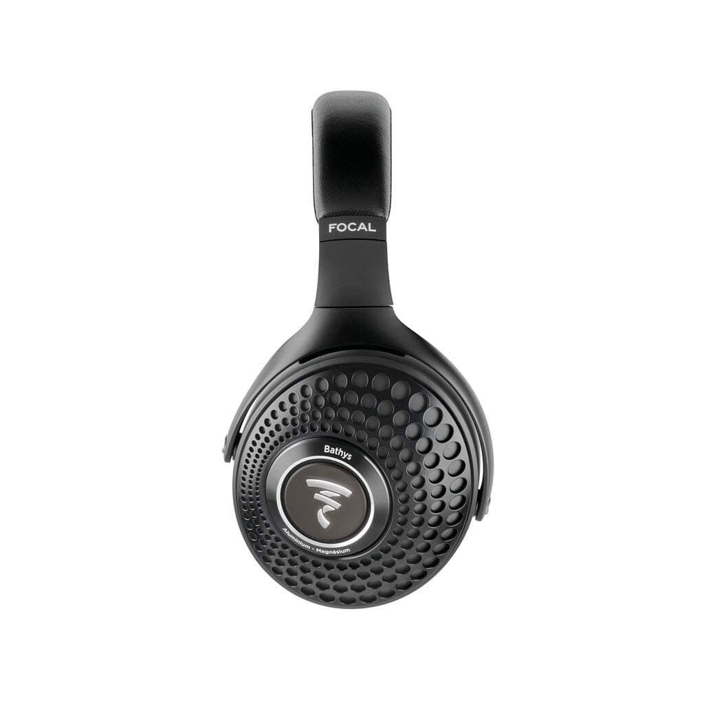 The Focal Bathys wireless noise-canceling headphones, finished in black, feature a textured circular pattern on the ear cups with the distinctive Focal logo at the center and “Bathys” displayed below it. Shown here against a white background, these over-ear headphones offer customizable EQ settings for a personalized listening experience.