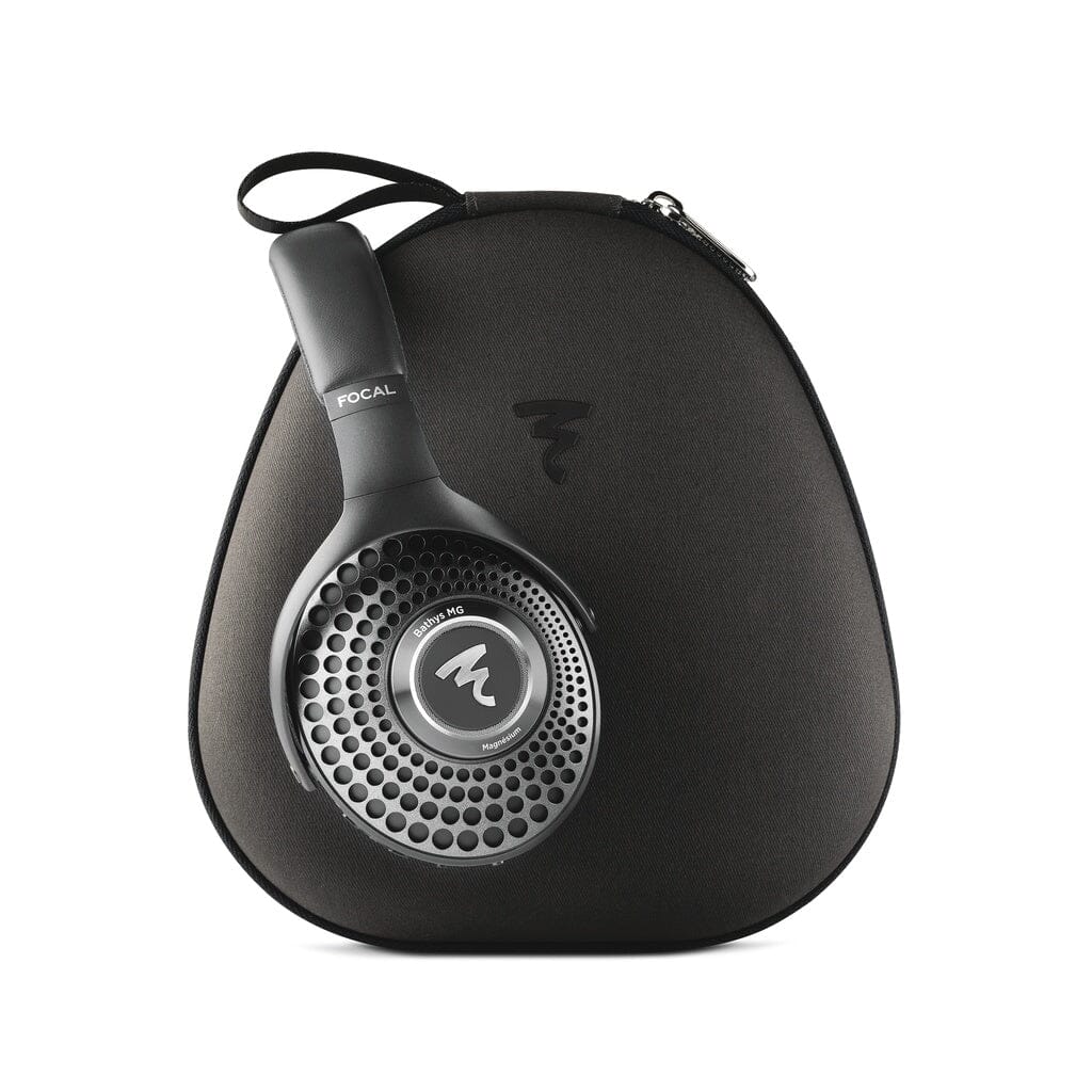 Focal Bathys MG wireless headphones with a circular, perforated silver earcup resting against a black zippered carrying case.