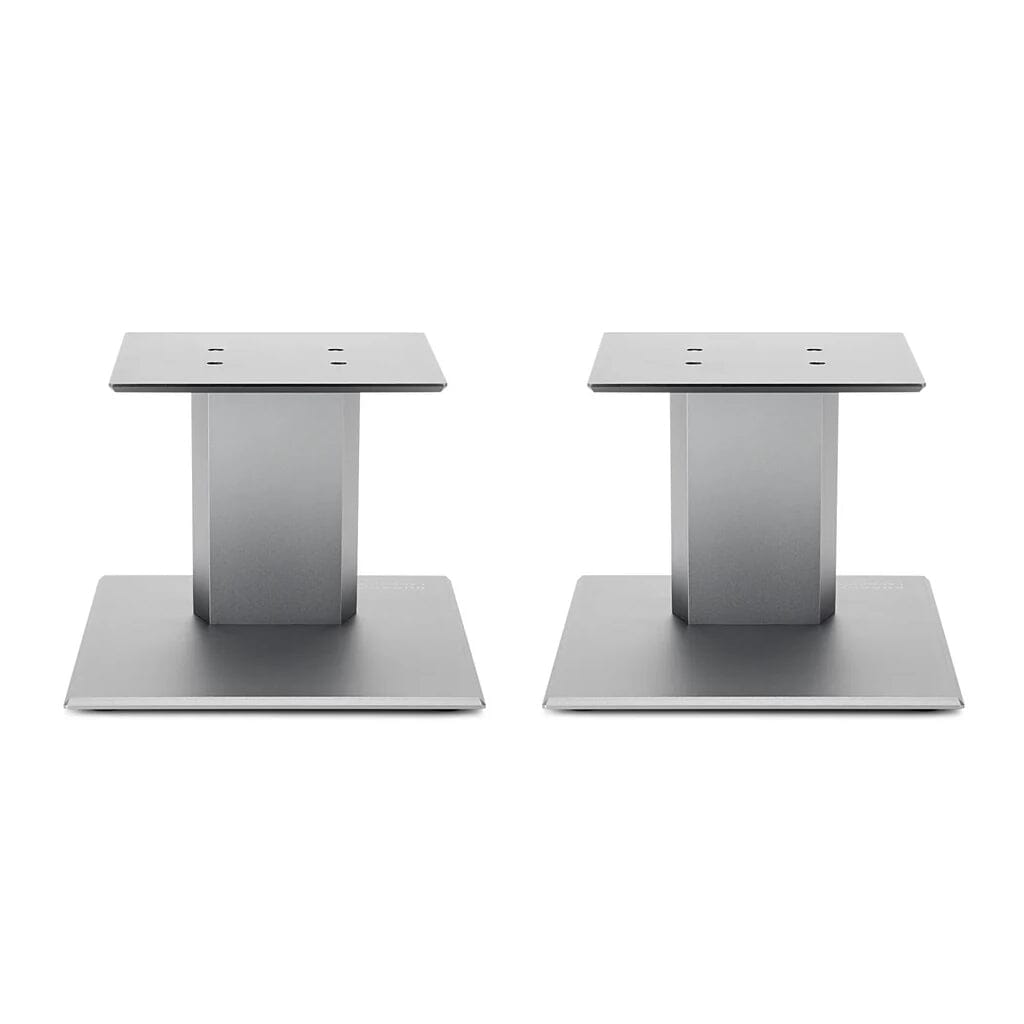 A pair of Burson Audio Launch Pad 50 Desktop Speaker Stands from Headphones.com, each with a flat base and vertical column, are positioned side by side against a white background—ideal for bookshelf speakers.