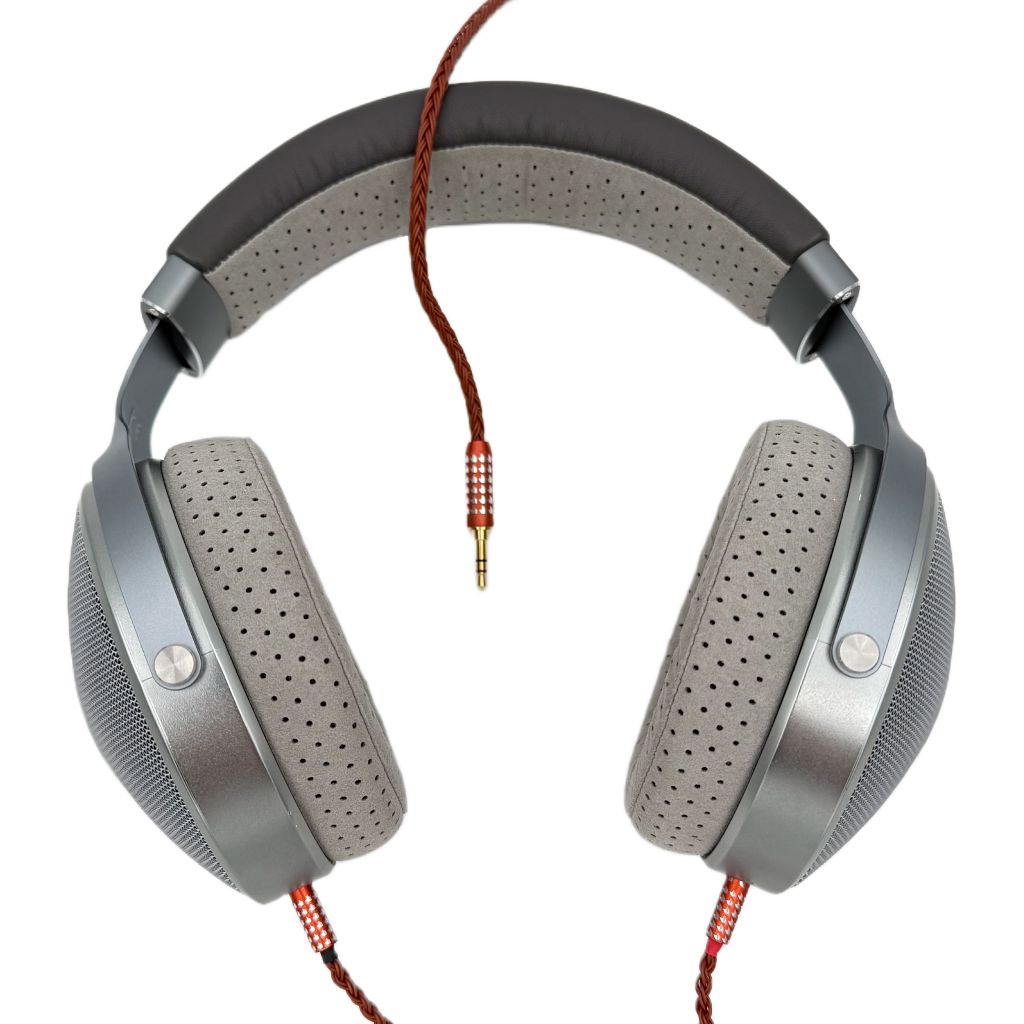 A pair of gray over-ear Listenmore headphones with perforated ear cushions, padded headband, and an Etched Headphone Cable featuring a 3.5mm plug, displayed against a white background.