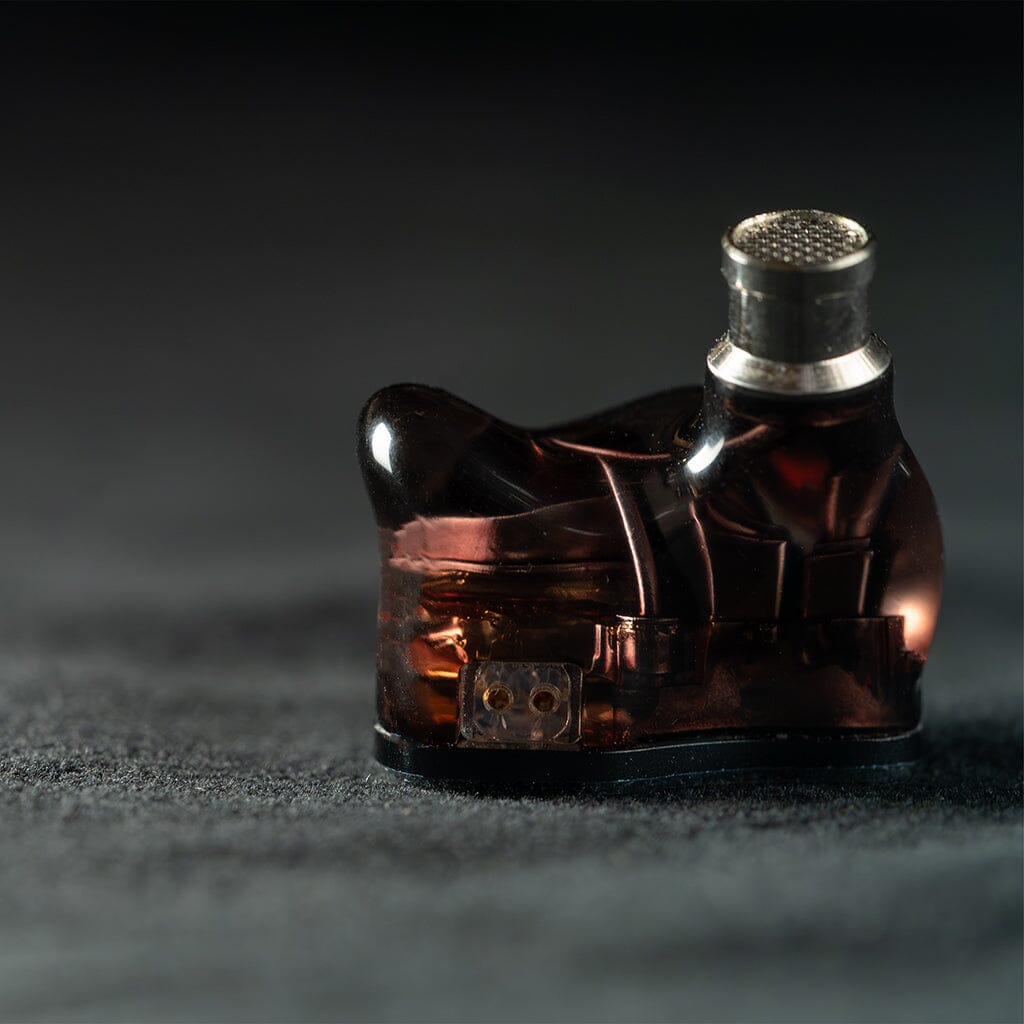 A single Crinear Daybreak In-Ear Headphones from Crinear, featuring a metallic mesh tip, rests on a textured dark surface and is displayed with shallow depth of field—highlighting its audiophile-grade sound quality.