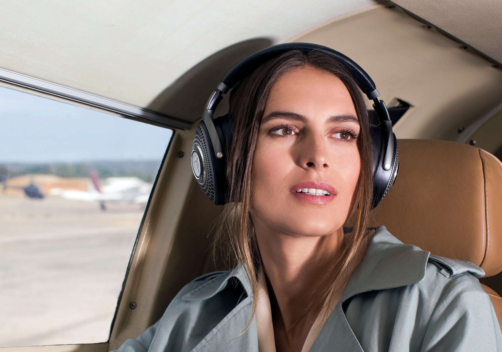 Woman wearing Focal Bathys headphones on plane