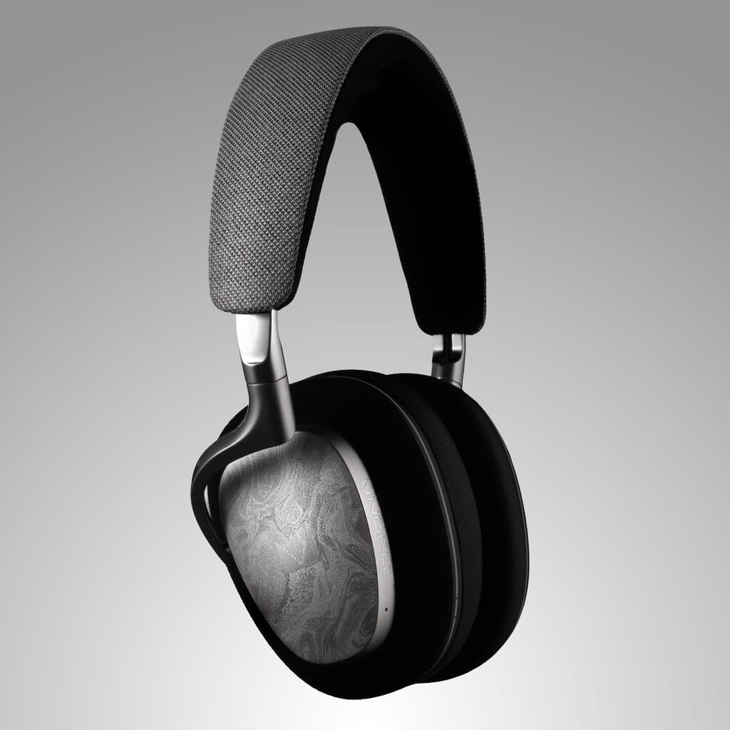 The Noble Audio FoKus Artemis Wireless Headphones by Noble Audio feature active noise cancellation, black ear cushions, textured silver outer ear cups, and a fabric-covered headband, shown against a plain gray background.