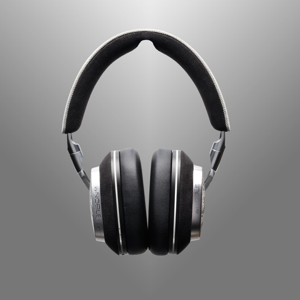 The Noble Audio FoKus Artemis Wireless Headphones by Noble Audio feature black and silver over-ear design, padded ear cups, and active noise cancellation, shown against a gray gradient background.