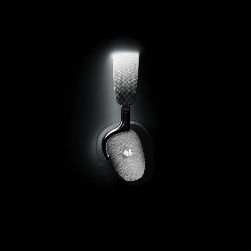 The Noble Audio FoKus Artemis Wireless Headphones by Noble Audio, with a metallic finish, stand illuminated against a black background. They feature active noise cancellation for an immersive listening experience.