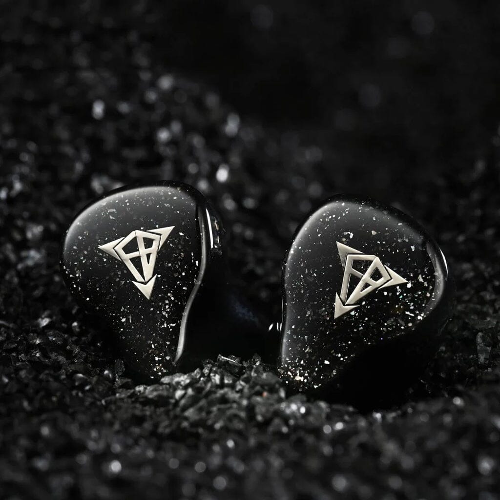 The Hisenior Mega7 In-Ear Headphones by Hisenior Audio feature a black 7-driver hybrid design with silver geometric logos and a speckled finish, displayed on shiny black stones—ideal for balanced, studio-quality sound.