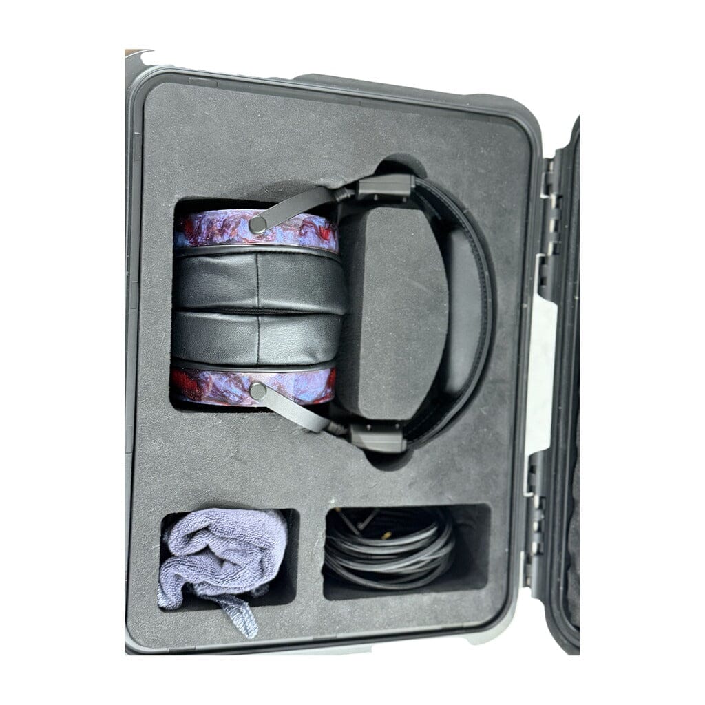 A pair of Rosson Audio Design RAD-0 headphones (Open Box C Condition, Clearance - 215) are neatly folded in their hard case with custom foam, accompanied by a coiled cable and a small cloth tucked into separate compartments—creating a polished open box presentation ideal for discerning audiophiles.