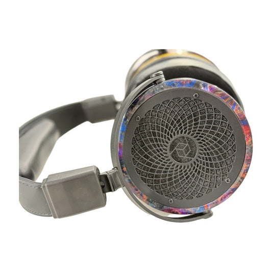 Close-up of a pair of Rosson Audio Design RAD-0 Headphones (Open Box - Clearance - 52), showcasing the geometric, spiral-inspired design on the ear cup and a vibrant, colorful rim encircling it.