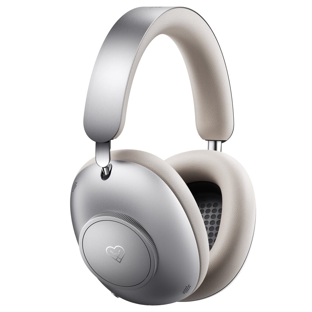 The Loewe Leo Wireless Headphones by Loewe are premium, silver over-ear headphones featuring cushioned light beige ear pads and a matching headband. With adaptive noise cancellation for an immersive listening experience, the modern and minimalistic design is highlighted by a small heart icon on the ear cup. The product is showcased against a clean white background.