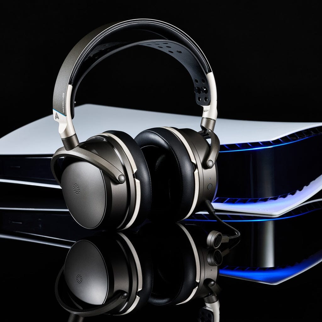 A pair of Audeze Maxwell 2 ANC Wireless Headphones by Audeze in black and silver, featuring a built-in microphone, rest on a white PlayStation 5 console against a black background illuminated by glowing blue lights from the console.