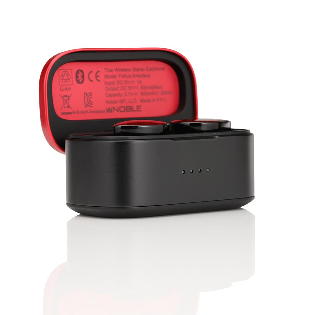 The Noble Audio FoKus Amadeus True Wireless In-Ear Headphones by Noble Audio rest in an open black charging case featuring a red interior with printed info, all displayed on a white reflective surface.
