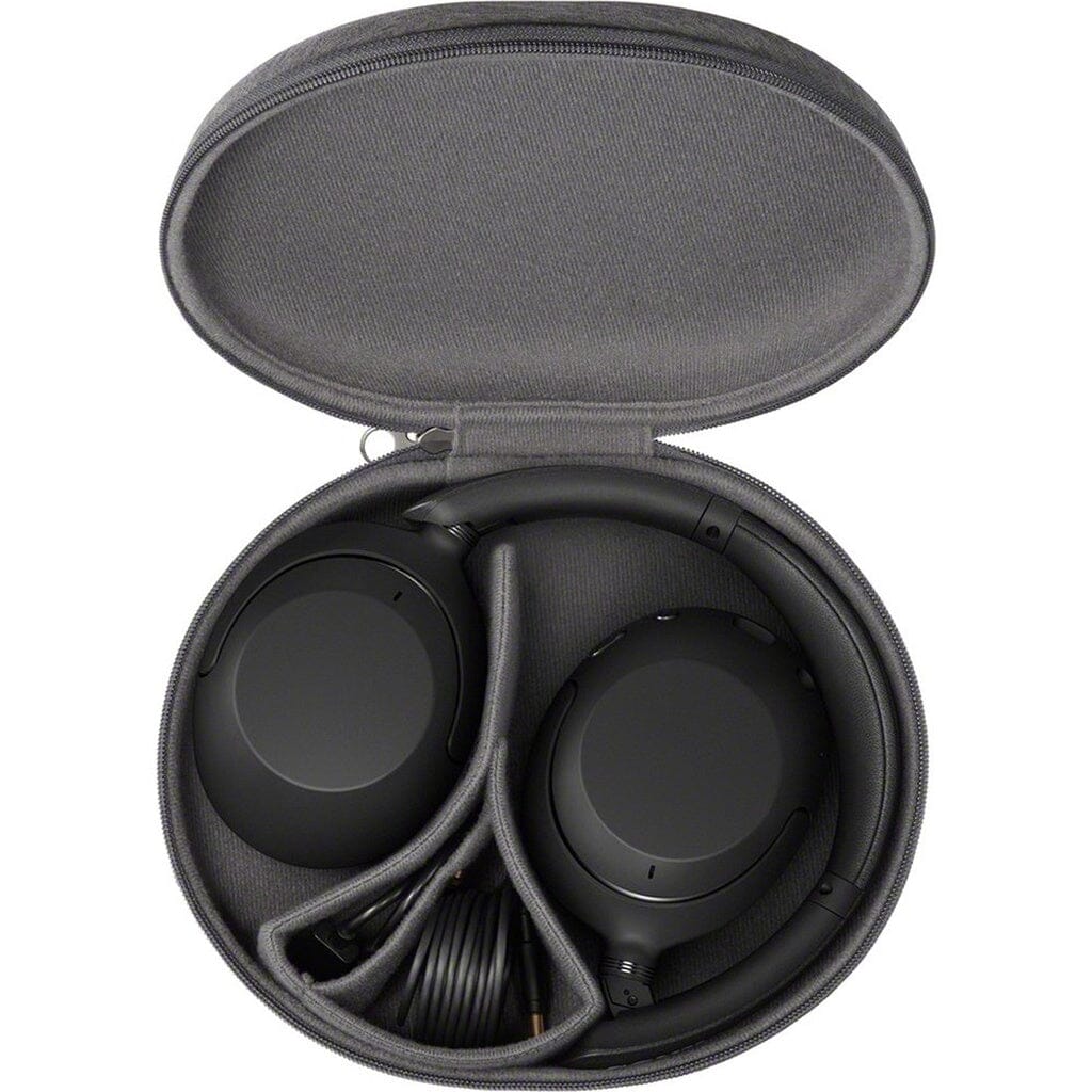 A pair of black Sony WHX-XB910N Wireless Headphones - Clearance by Sony and a coiled cable are neatly packed inside an open, oval-shaped gray carrying case.